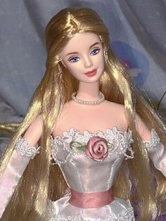 a barbie doll with blonde hair wearing a white dress