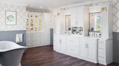 a large bathroom with white cabinets and wood flooring is pictured in this image, there are two sinks on the far side of the bathtub