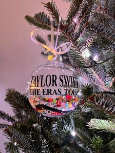 a glass ornament hanging from the top of a christmas tree with candy in it