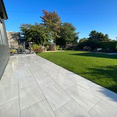 an empty backyard with grass and trees in the background