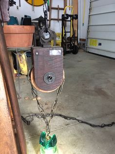 a green bottle is chained to a chain in a garage with other items around it