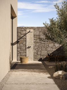 an outdoor shower in front of a stone wall