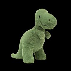 a green dinosaur stuffed animal on a black background