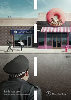 a man walking down the street in front of a donut shop with a pink doughnut on it