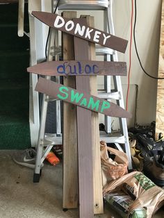 a wooden sign sitting on top of a pile of bags next to a step ladder