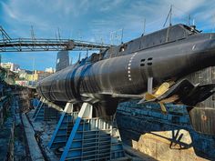 a large black submarine sitting on top of a bridge