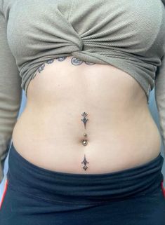 a woman's stomach with an arrow tattoo on her belly and the bottom part of her lower body