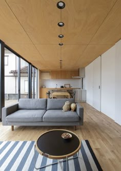 a living room filled with furniture next to a window covered in wooden slatted walls