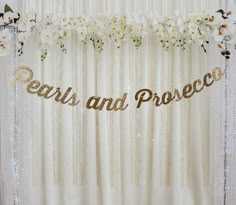 there is a sign that says pearls and proceed on the curtain with flowers in front of it