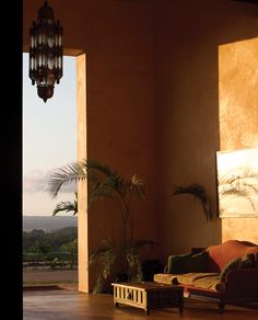 a living room with an open door leading to a balcony and view of the mountains