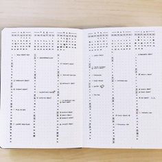 an open planner book sitting on top of a wooden table