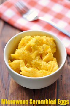 microwave scrambled eggs in a white bowl on a wooden table