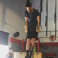 a man standing on top of a wooden box in a gym