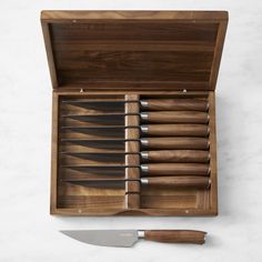 a wooden box with six knives in it