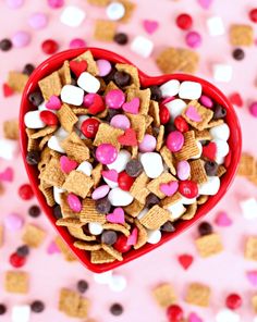 a heart shaped bowl filled with valentine's day cereal and marshmallows