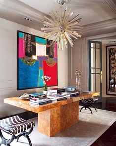 a living room filled with furniture and a chandelier hanging over the top of a wooden table