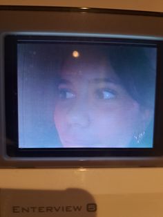 a woman's face is seen on the screen of an entertainment center