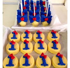 cupcakes with blue and red frosting are arranged in rows on a table