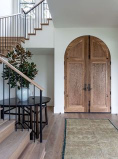 an entryway with wooden doors and stairs