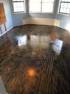 an empty room with blue walls and wood floors