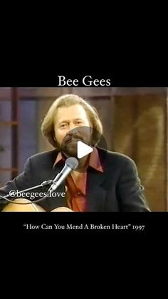 a man holding a guitar in front of a microphone with the words bee gees on it