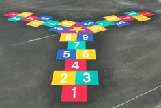 a colorful cross made out of squares on the ground with numbers painted all over it