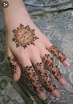 a woman's hand with henna tattoos on it