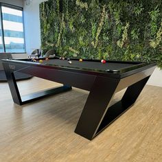 a pool table in front of a green wall