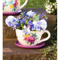 two tea cups with flowers painted on them