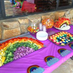 a table topped with lots of rainbow treats