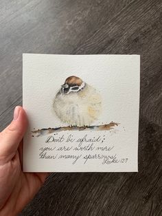 a hand holding a card with a bird on it