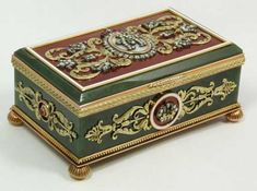 a green and gold box with ornate designs on it