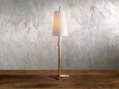 a lamp that is sitting on top of a wooden table in front of a wall