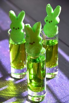 three glasses filled with green liquid and peeps in them