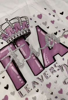 a white shirt with purple letters and a crown on it