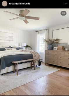 a bed room with a neatly made bed and a ceiling fan