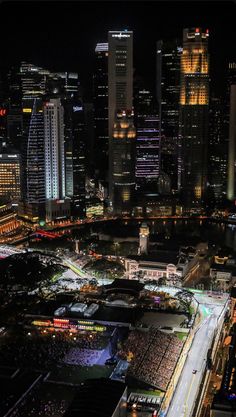 an aerial view of a city at night with lots of lights on the buildings and streets