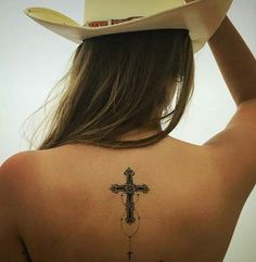 a woman with a cross tattoo on her back