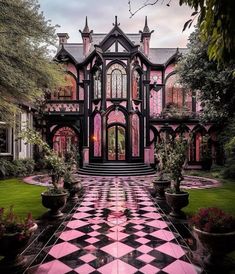 a large pink and black checkered floor in front of a house with lots of windows