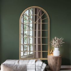 a room with green walls and a large mirror on the wall next to a bench