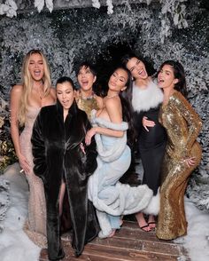 several women posing for a photo in front of snow covered trees