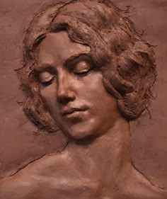 a close up of a statue of a person with eyes closed and hair blowing in the wind