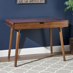 a wooden table with a drawer underneath it in a living room next to a potted plant