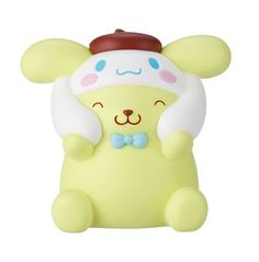 a small yellow toy with a hat and bow tie on it's head sitting in front of a white background