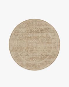 a round rug with an intricate design in beige and tan tones on a white background