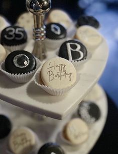 a birthday cake decorated with cupcakes and chocolate candies in the shape of numbers