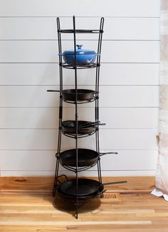 a stack of black plates sitting on top of a wooden floor