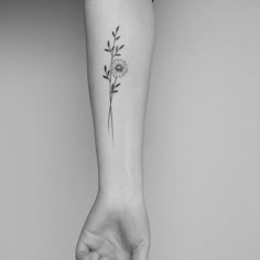 a woman's arm with a flower tattoo on it and a hand holding the wrist