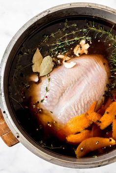 the best turkey brine recipe in a pot with carrots and herbs