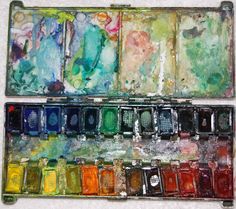 an artist's watercolor palette with many different colors and shapes in the case